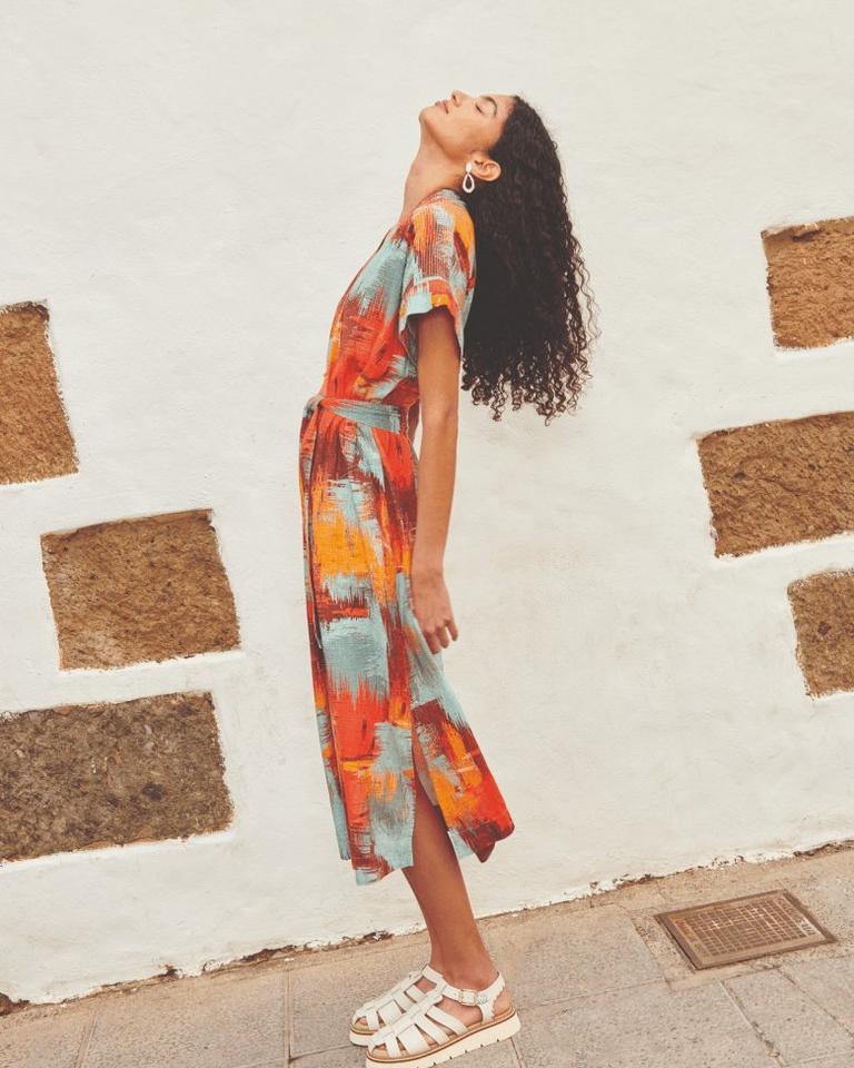 Woman in printed linen dress looking up